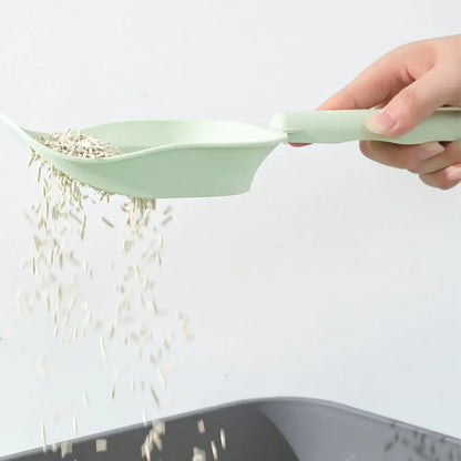 Green rice scoop being used to pour rice into a container on a white background
