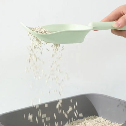 Green scoop pouring rice into a black container on a white background