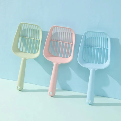 Three colorful pet grooming tools on a light blue background