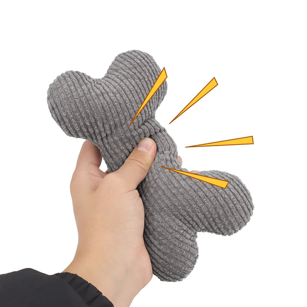 Hand holding a gray textured bone-shaped toy with yellow arrows indicating flexibility on a white background