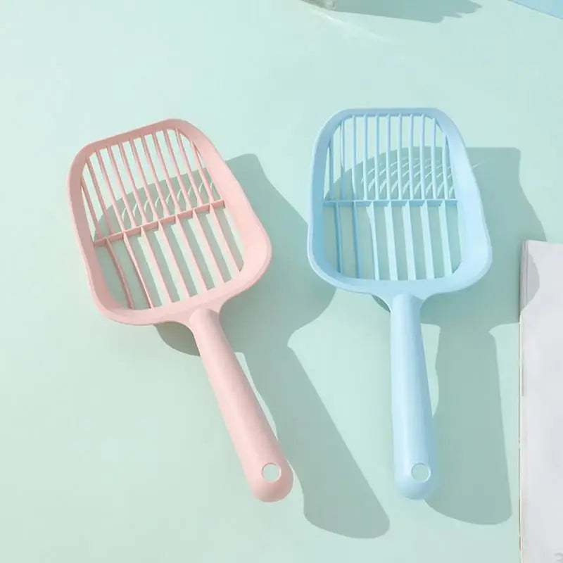 Two pet grooming tools, one pink and one blue, on a light blue background.