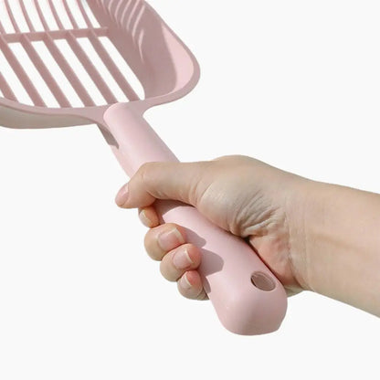 Hand holding a pink pet grooming brush against a white background